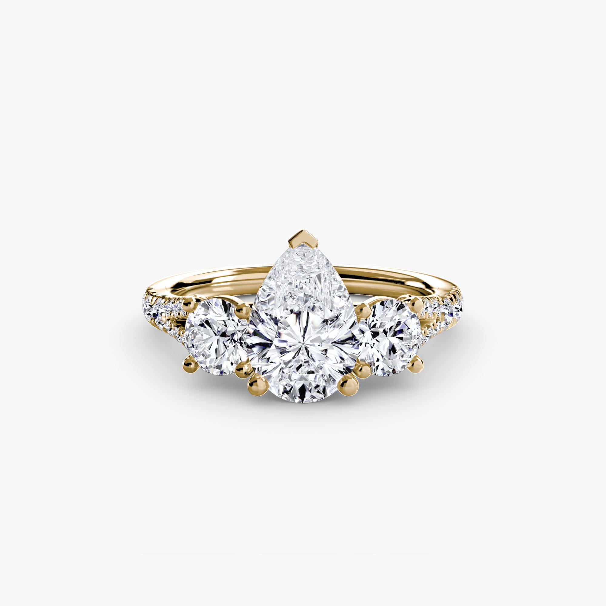 The MICHAEL ISAAC Three-Stone with Pavé Band 3 features a large pear-shaped diamond centered between two round diamonds, with pavé-set accents along the gold band, all shown on a plain white background.