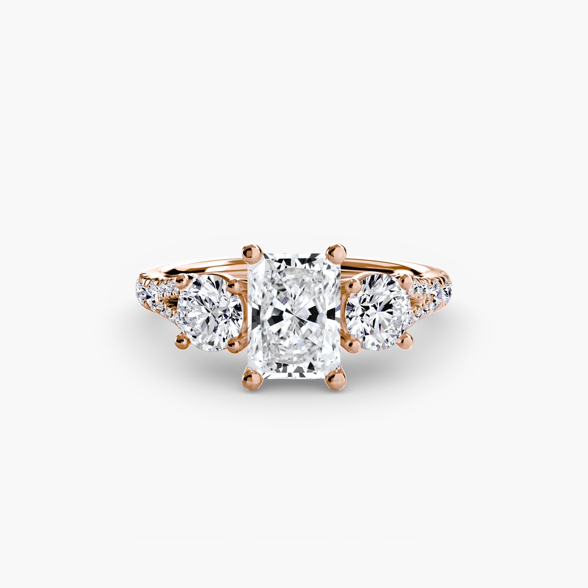 The MICHAEL ISAAC Three-Stone with Pavé Band 3 is an elegant rose gold ring featuring a radiant-cut center diamond, two round side stones, and a pavé band adorned with sparkling accent diamonds.