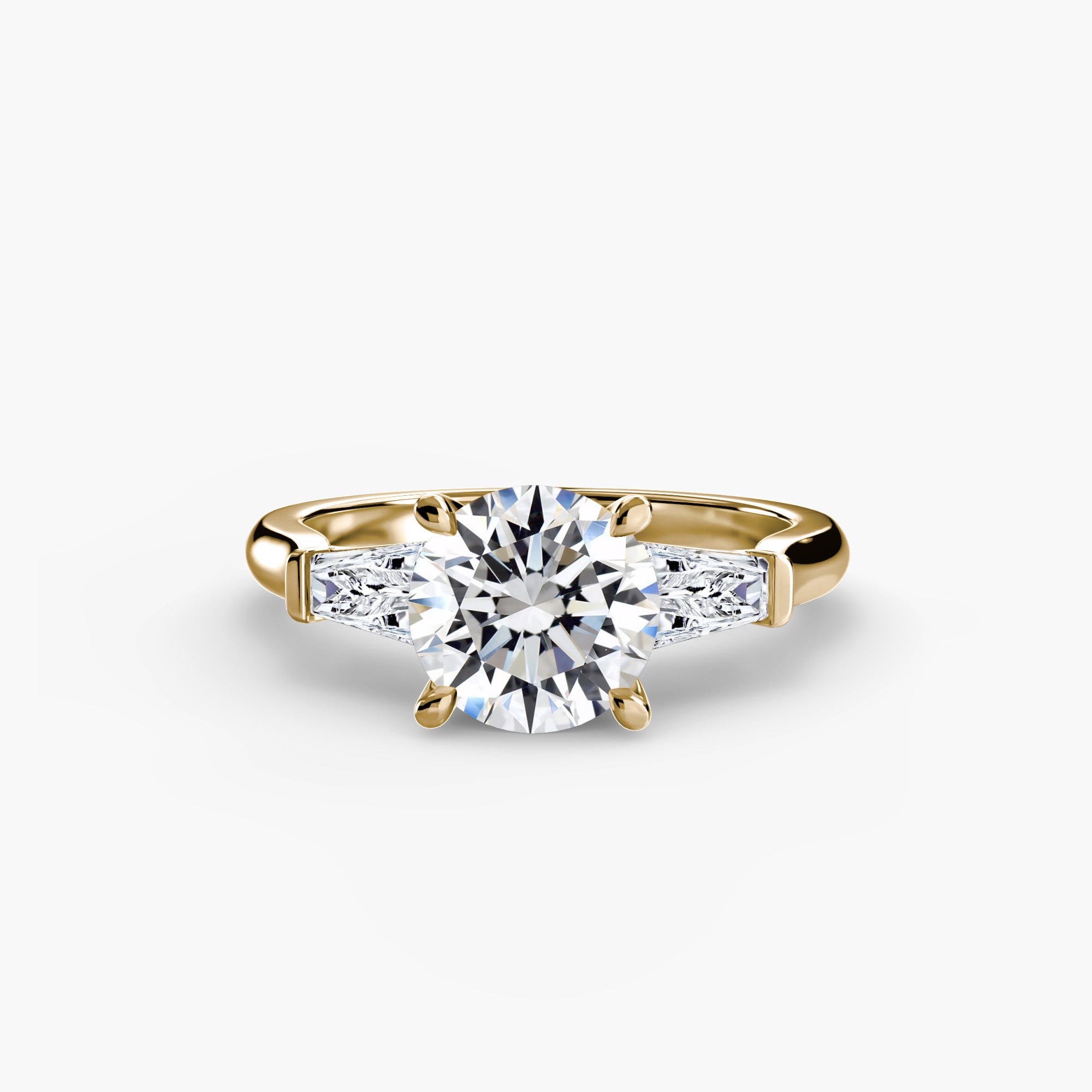 The MICHAEL ISAAC Three-Stone Ring (Baguette Side Stones) showcases a gold band with a large round diamond center and two smaller rectangular baguette diamonds, set against a white background.