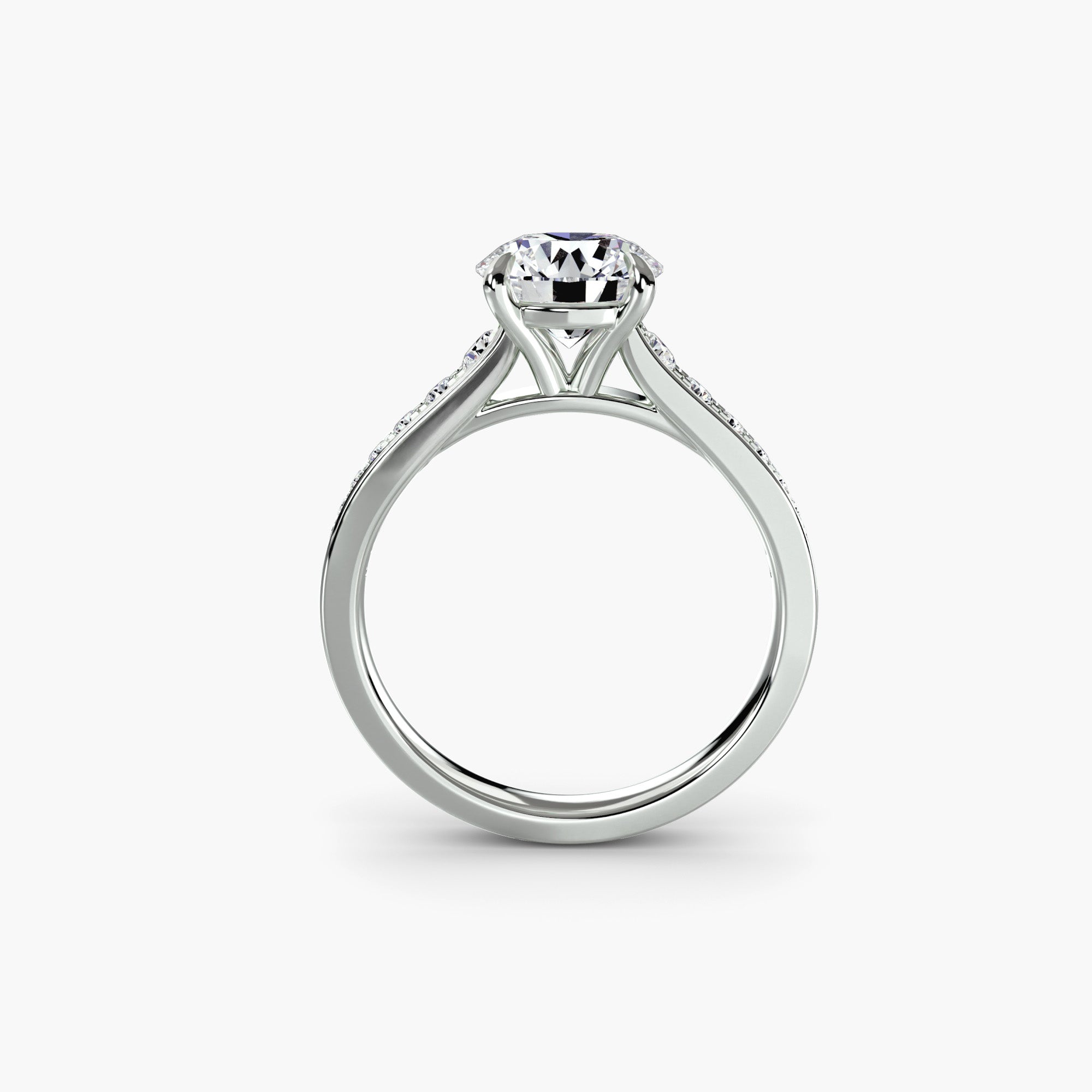 The MICHAEL ISAAC Solitaire with Pavé 7 is a silver ring with a large round-cut diamond in a prong setting, viewed from the side on a white background. The sleek band features pavé-set accent stones along the shoulders for added elegance.