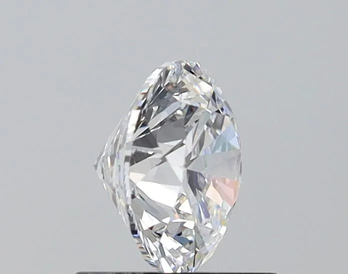 A close-up of a 1.00 ct Round NONE certified Loose diamond (D color, VVS2 clarity, EX cut) from MICHAEL ISAAC stands upright on a dark surface, its facets and reflections sparkling—ideal inspiration for exquisite engagement rings.