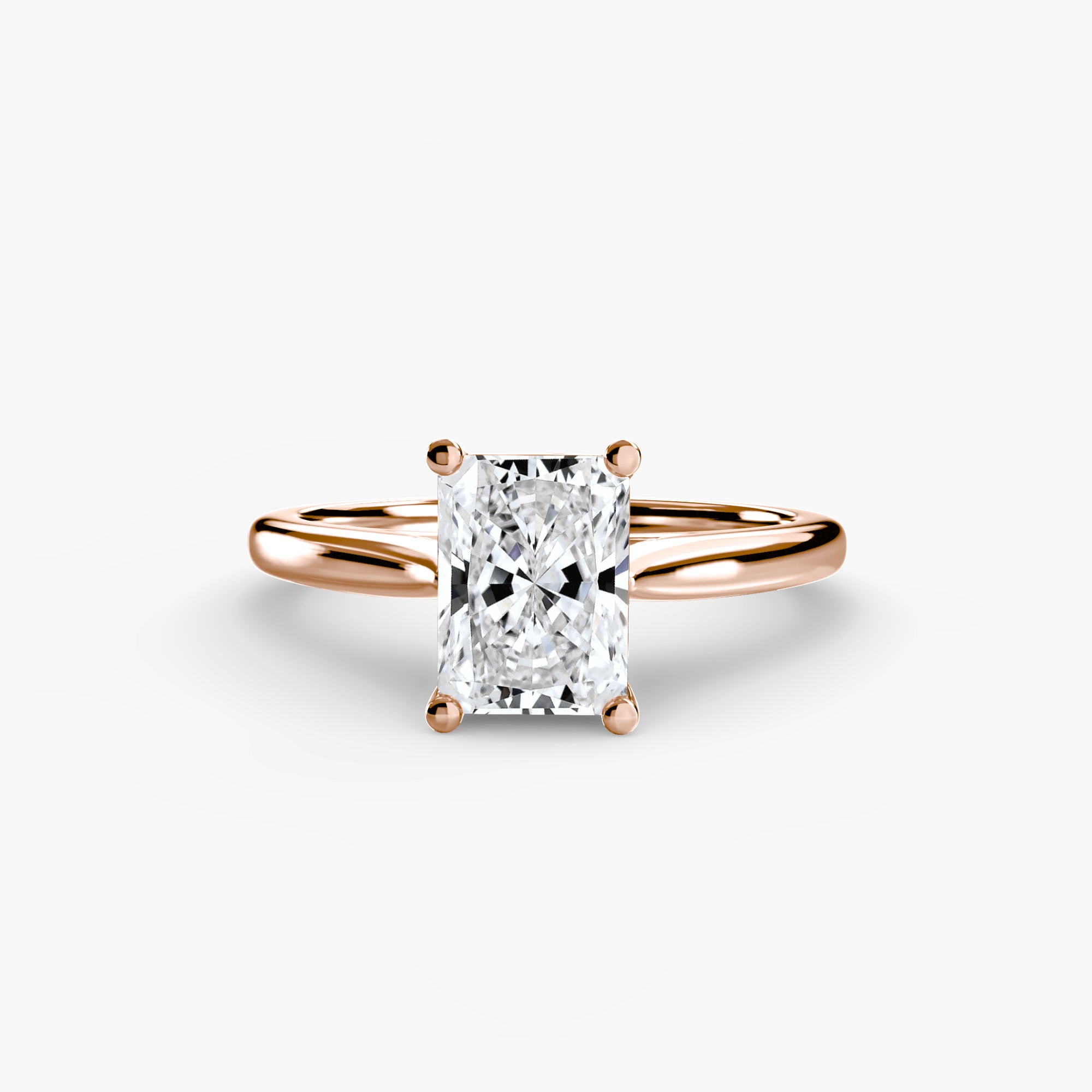 The Solitaire ring 1 by MICHAEL ISAAC features a radiant-cut diamond in a classic setting on a minimalist rose gold band, showcased against a crisp white background.