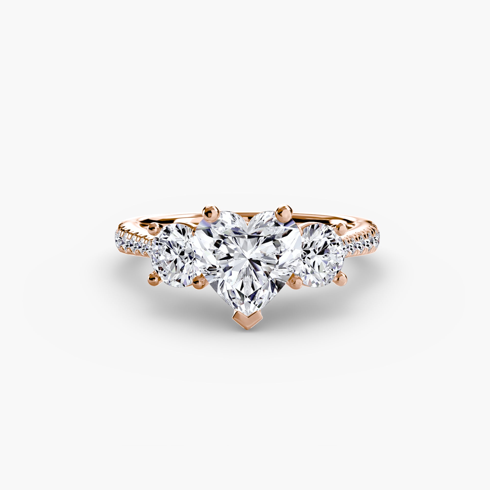 The Three-Stone with Pavé Band ring by MICHAEL ISAAC features a heart-shaped diamond center, two round side diamonds, and a pavé band set with sparkling small diamonds for an elegant look.