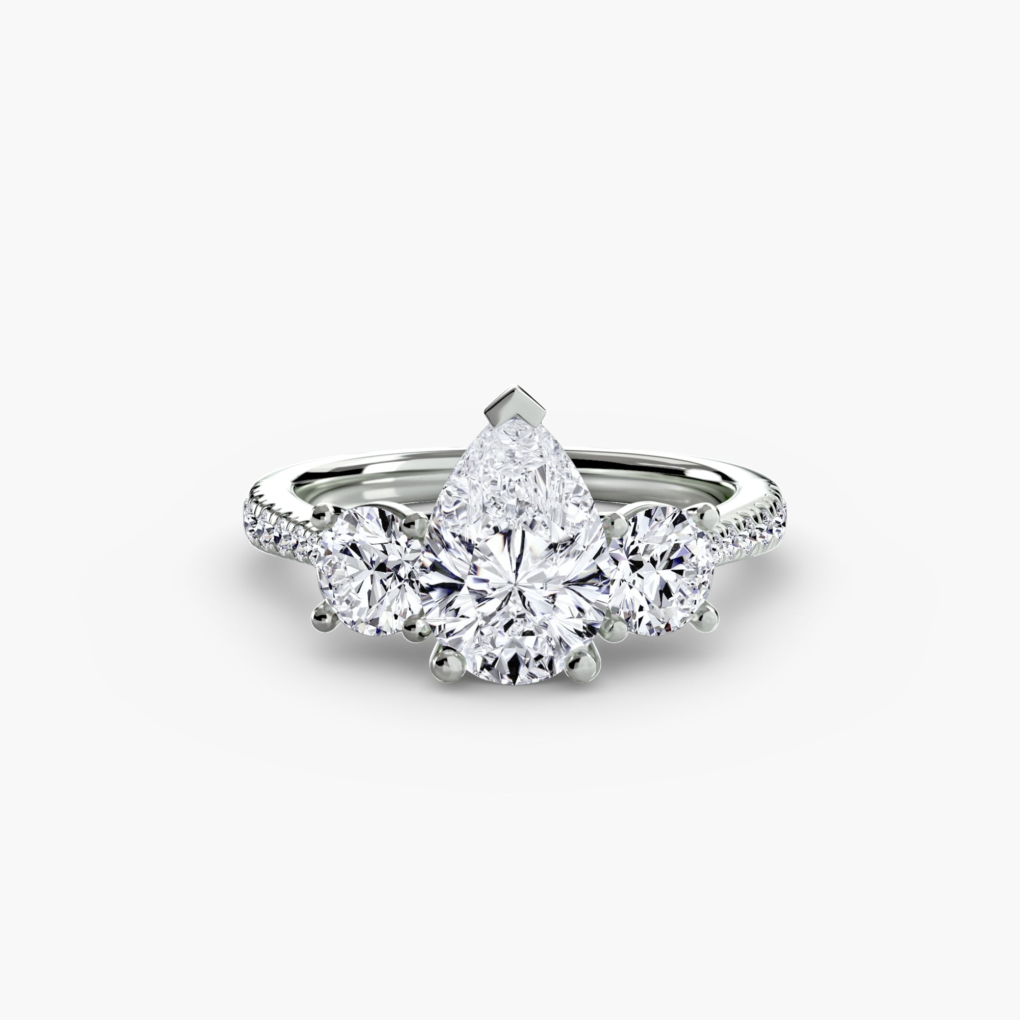 The MICHAEL ISAAC Three-Stone with Pavé Band features a pear-shaped center diamond, two round side diamonds, and additional pavé-set stones on an elegant white gold band.