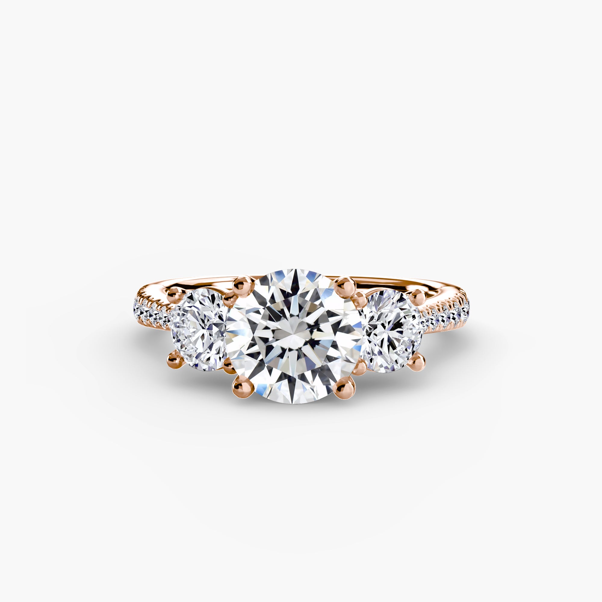 The MICHAEL ISAAC Three-Stone with Pavé Band is an elegant rose gold ring, showcasing a large round center diamond, two smaller side diamonds, and a pavé band, displayed on a white background.