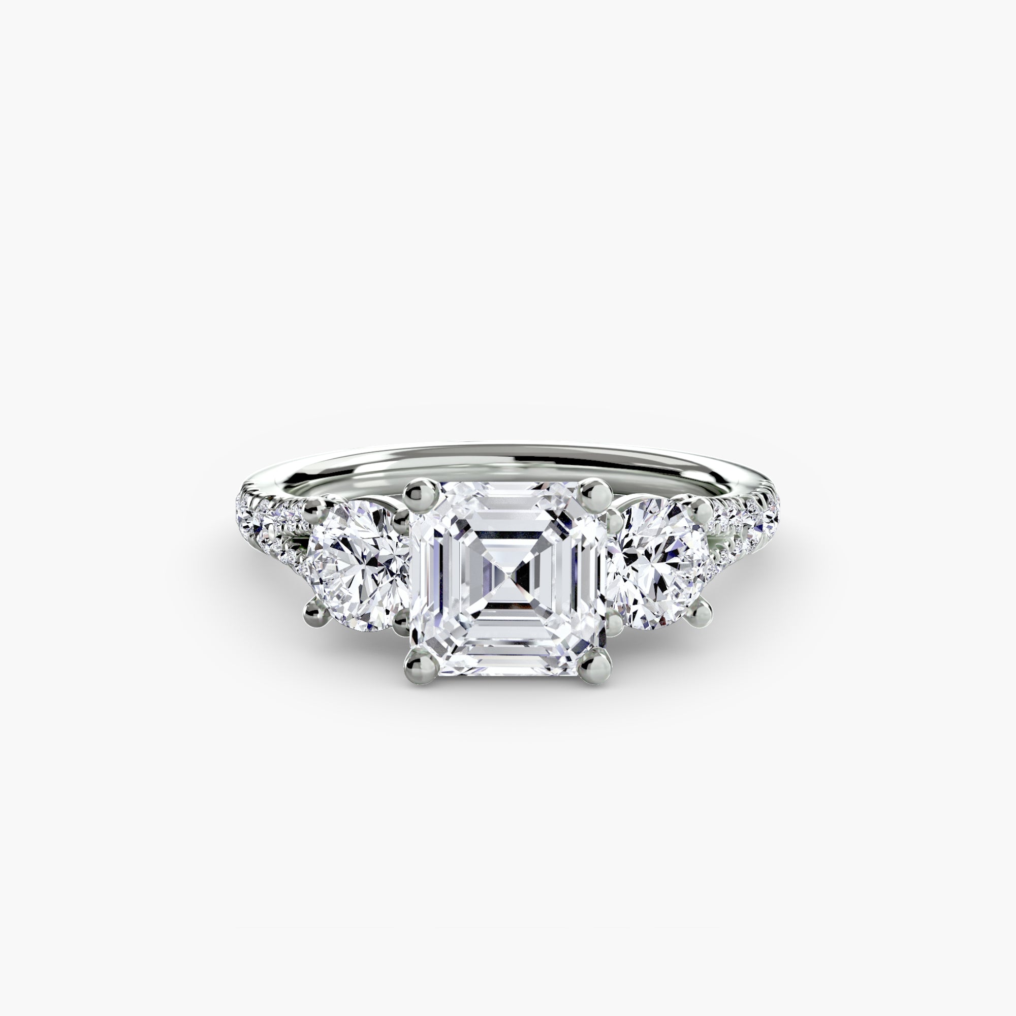 The MICHAEL ISAAC Three-Stone with Pavé Band 3 features a large square-cut center diamond flanked by two round diamonds, all set in platinum in a timeless, elegant design.