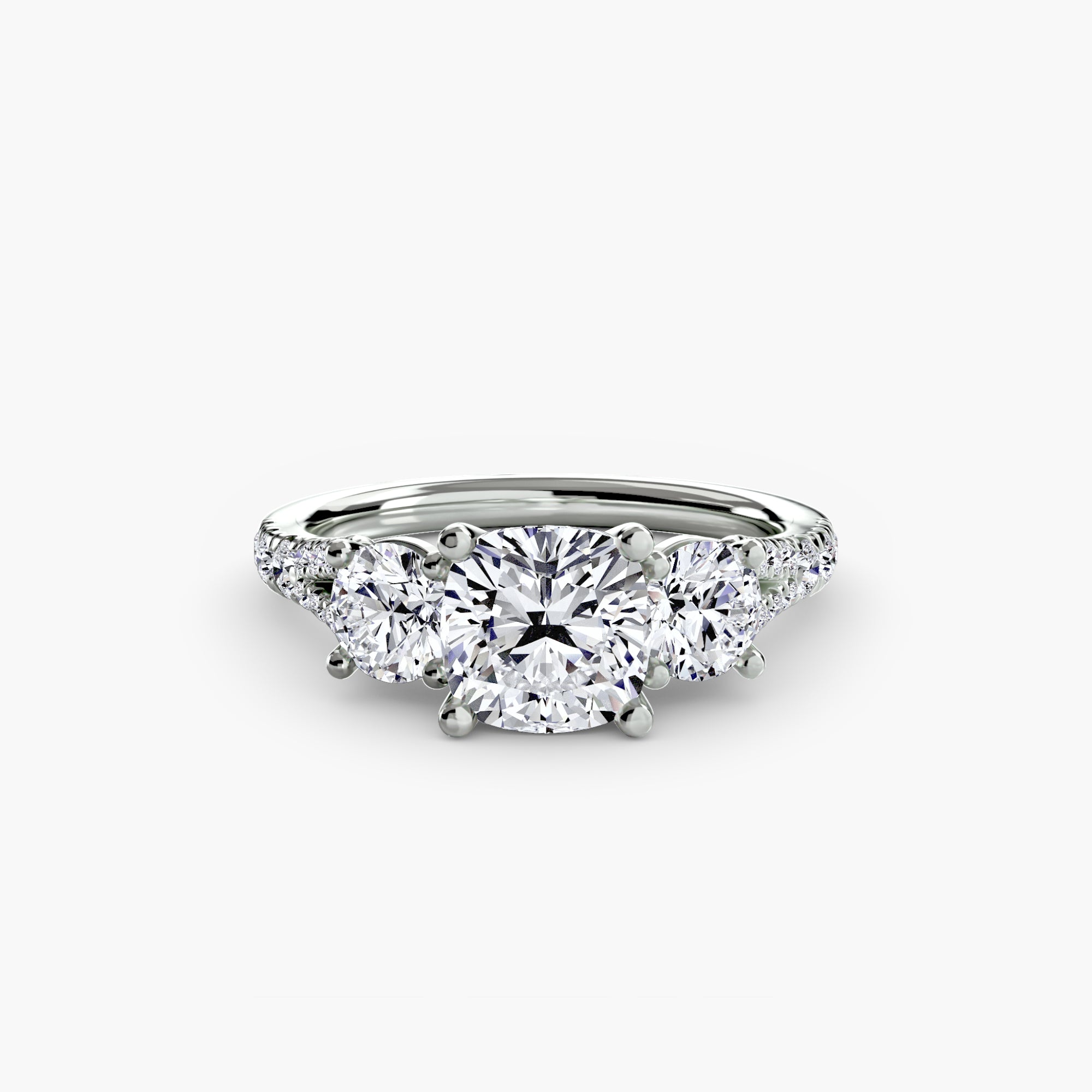 The MICHAEL ISAAC Three-Stone with Pavé Band 3 ring features a large round center diamond, two smaller side diamonds, and a silver pavé band set with extra diamonds along the shoulders.
