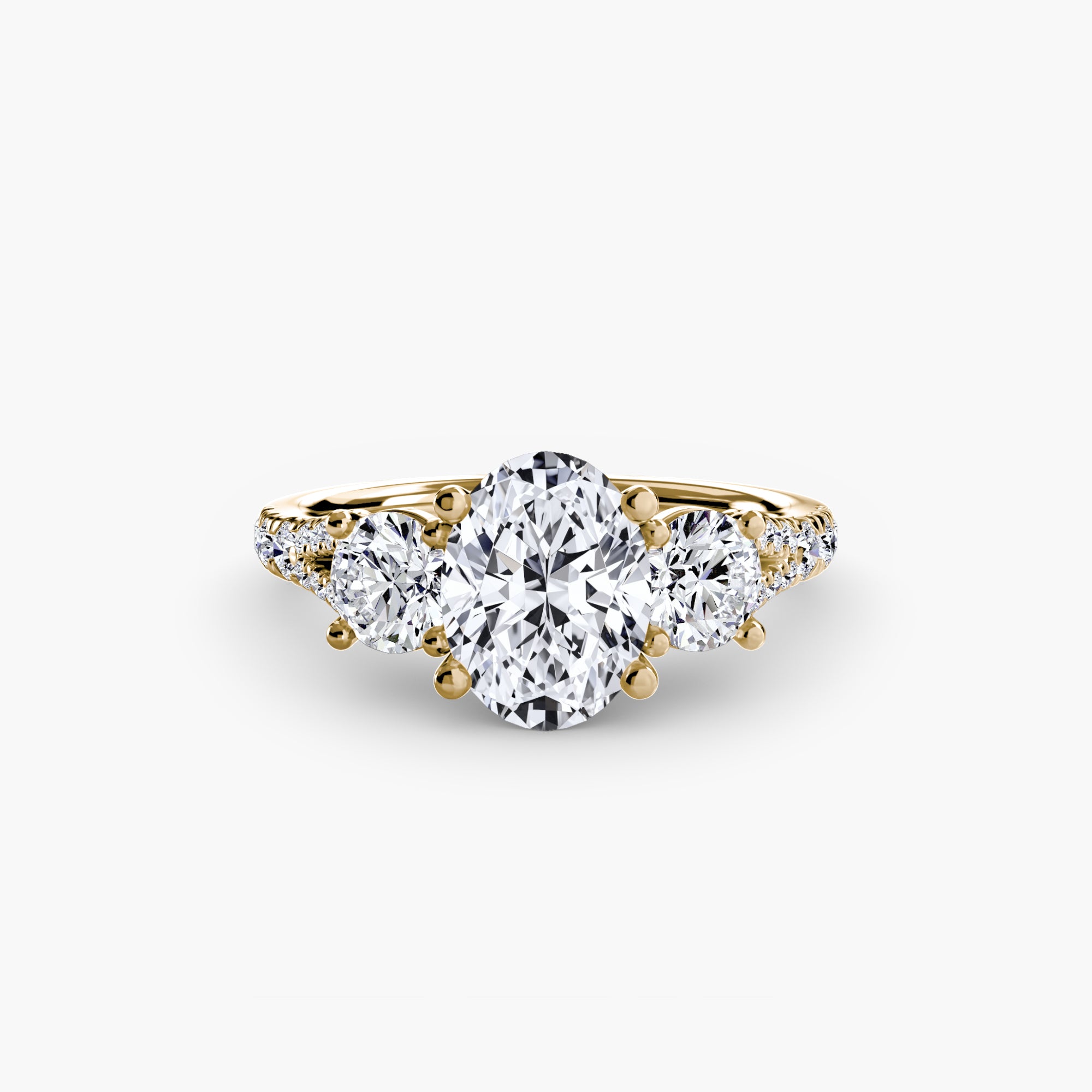 The MICHAEL ISAAC Three-Stone with Pavé Band 3 features an elegant gold band with an oval center diamond flanked by two round diamonds, displayed against a plain white background.