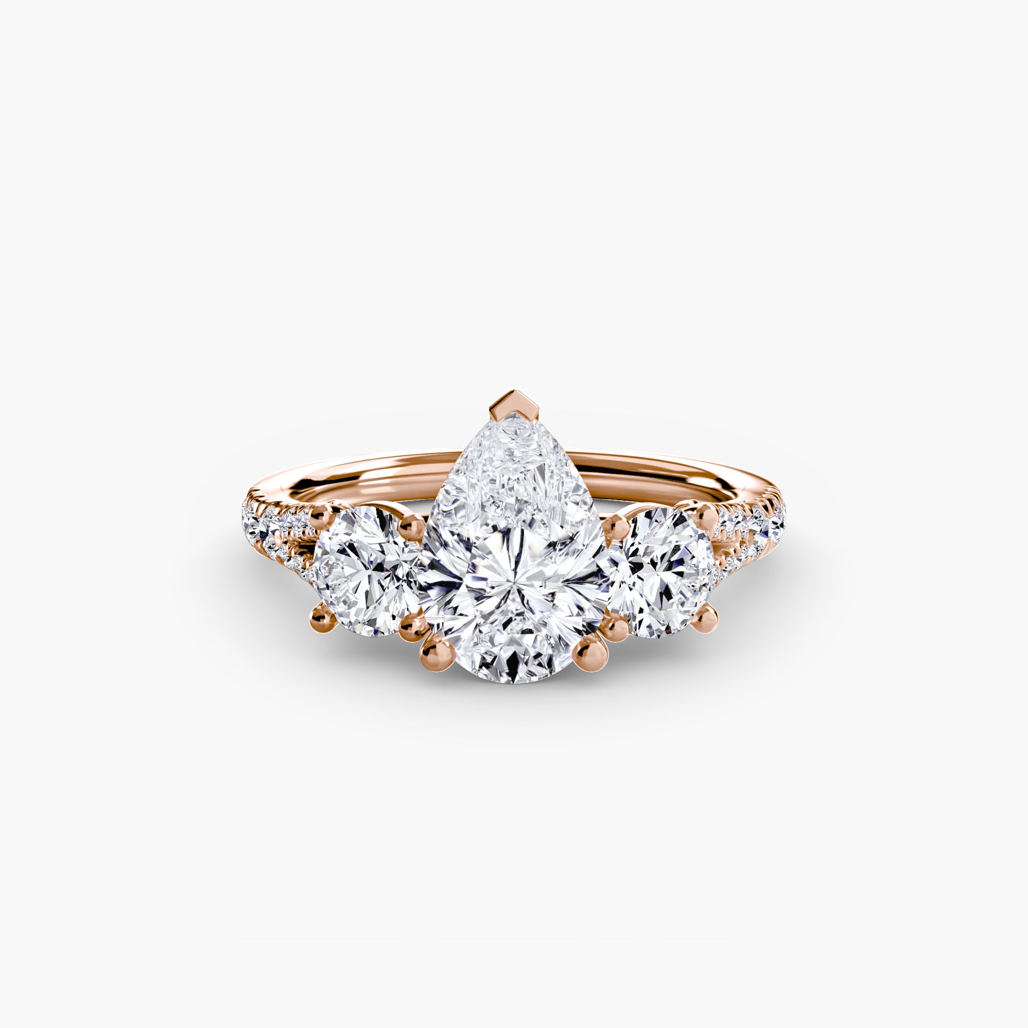 The MICHAEL ISAAC Three-Stone with Pavé Band 3 is an elegant gold ring featuring a large pear-shaped center diamond, round side diamonds, and a pavé diamond band, beautifully displayed against a white background.