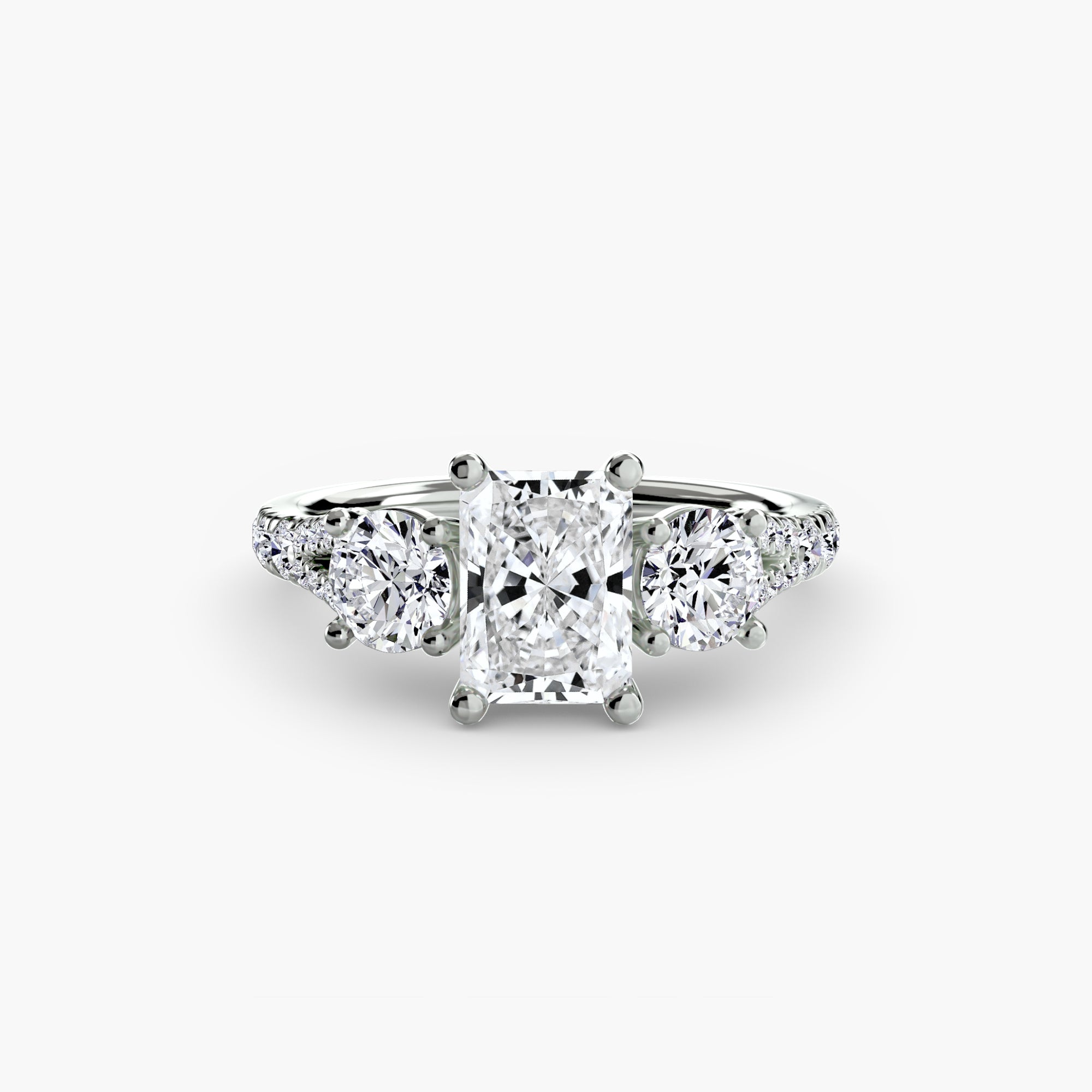 The MICHAEL ISAAC Three-Stone with Pavé Band 3 features a radiant-cut center diamond, two round side diamonds, and a pavé band in white gold or platinum, shown on a white background.