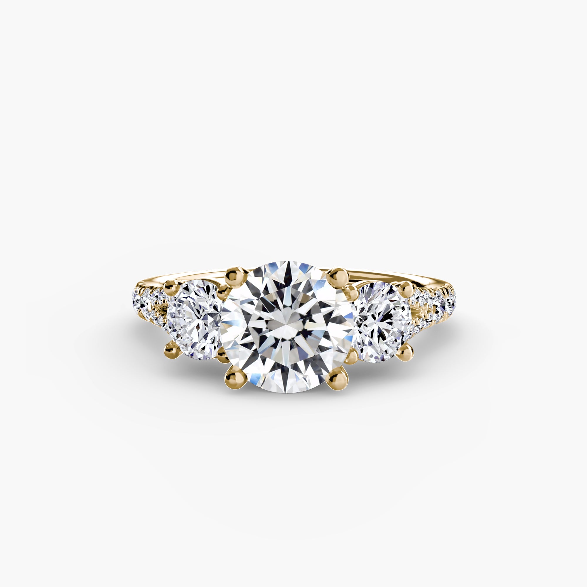 The "Three-Stone with Pavé Band 3" ring by MICHAEL ISAAC features a gold band with a large round center diamond and two smaller round diamonds on each side.