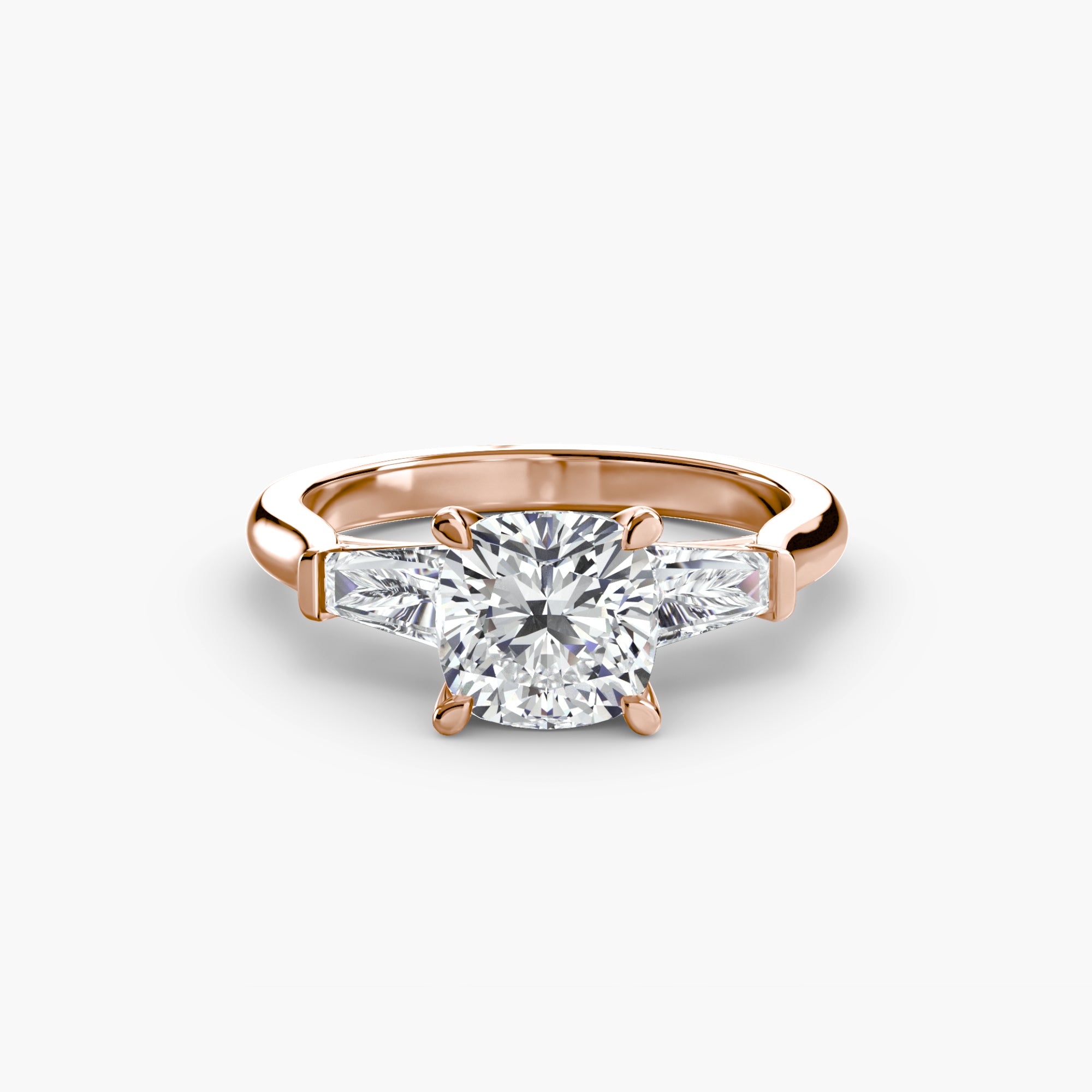 The MICHAEL ISAAC Three-Stone Ring features a cushion-cut diamond center with baguette side stones in a classic rose gold setting, shown on a plain white background.