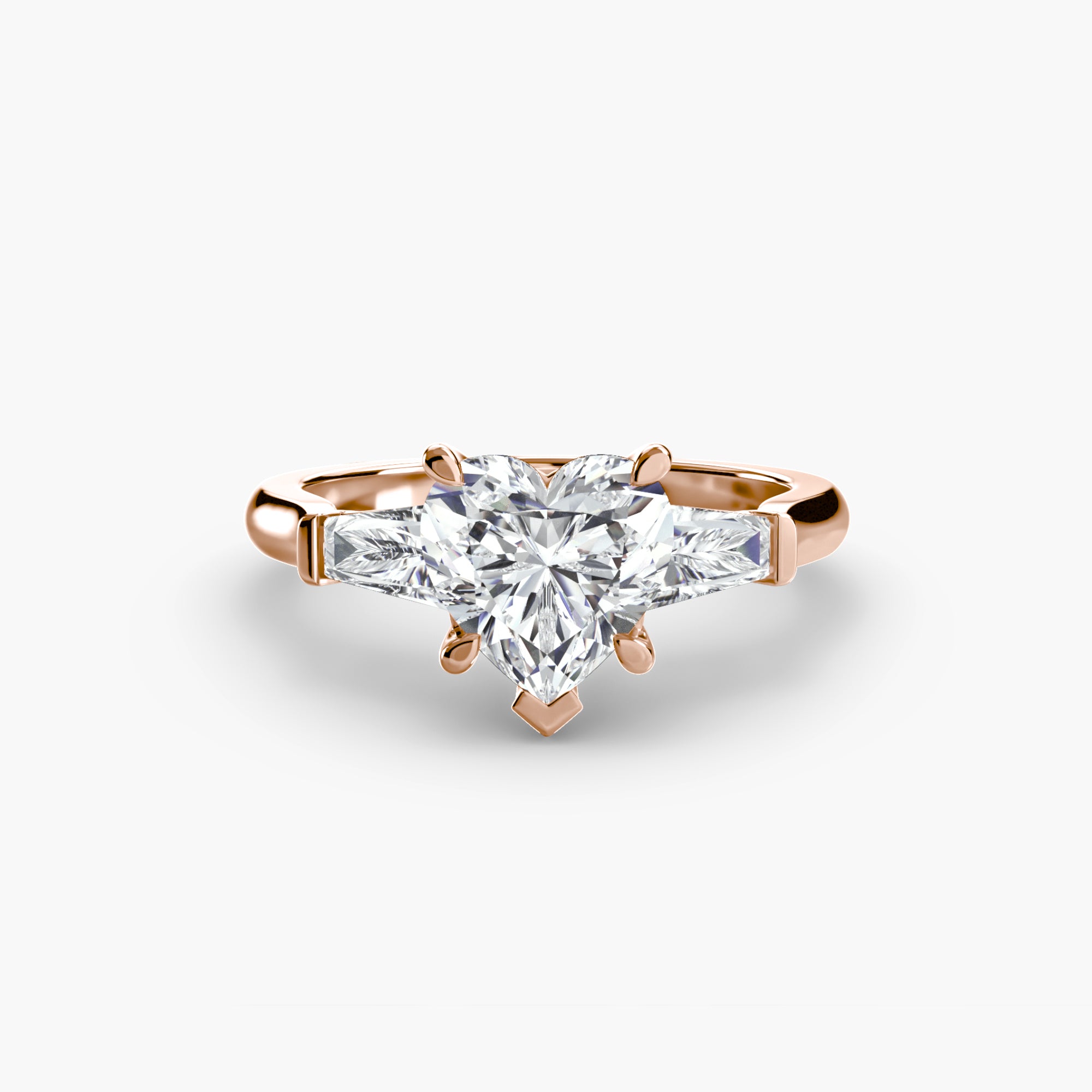 The MICHAEL ISAAC Three-Stone Ring features a rose gold band with a heart-shaped diamond center stone and two baguette side stones, showcased on a simple band against a white background.