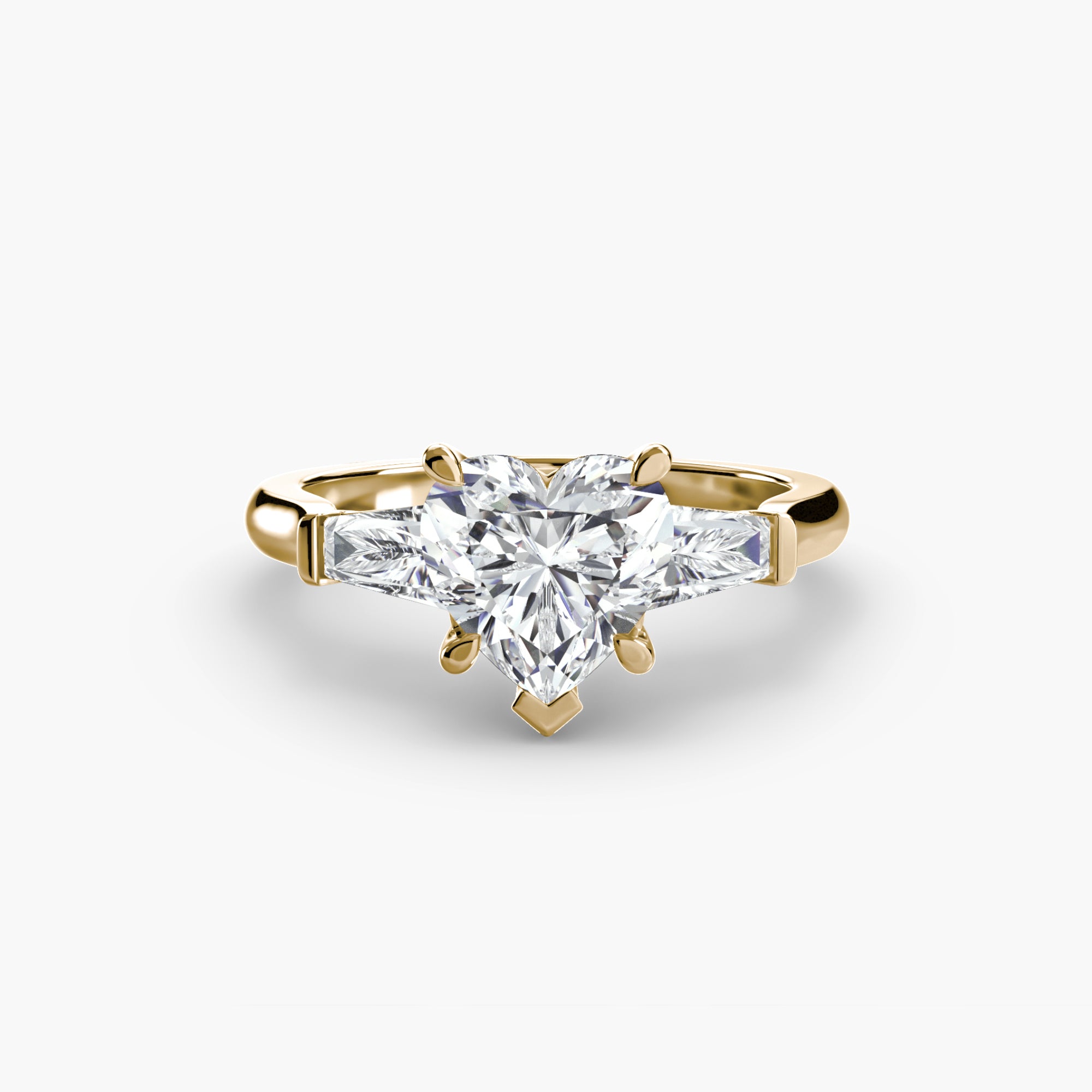 The MICHAEL ISAAC Three-Stone Ring features a gold band with a heart-shaped diamond center and two baguette side stones, displayed on a plain white background.