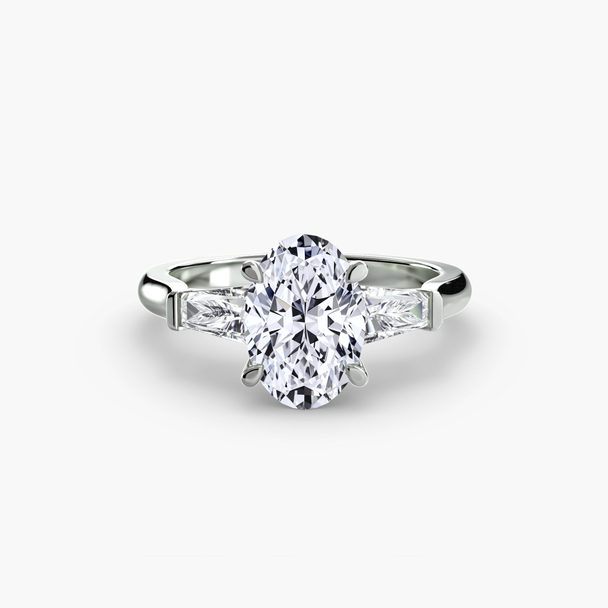 The MICHAEL ISAAC Three-Stone Ring features a central oval-cut diamond with baguette side stones in platinum, displayed on a white background.