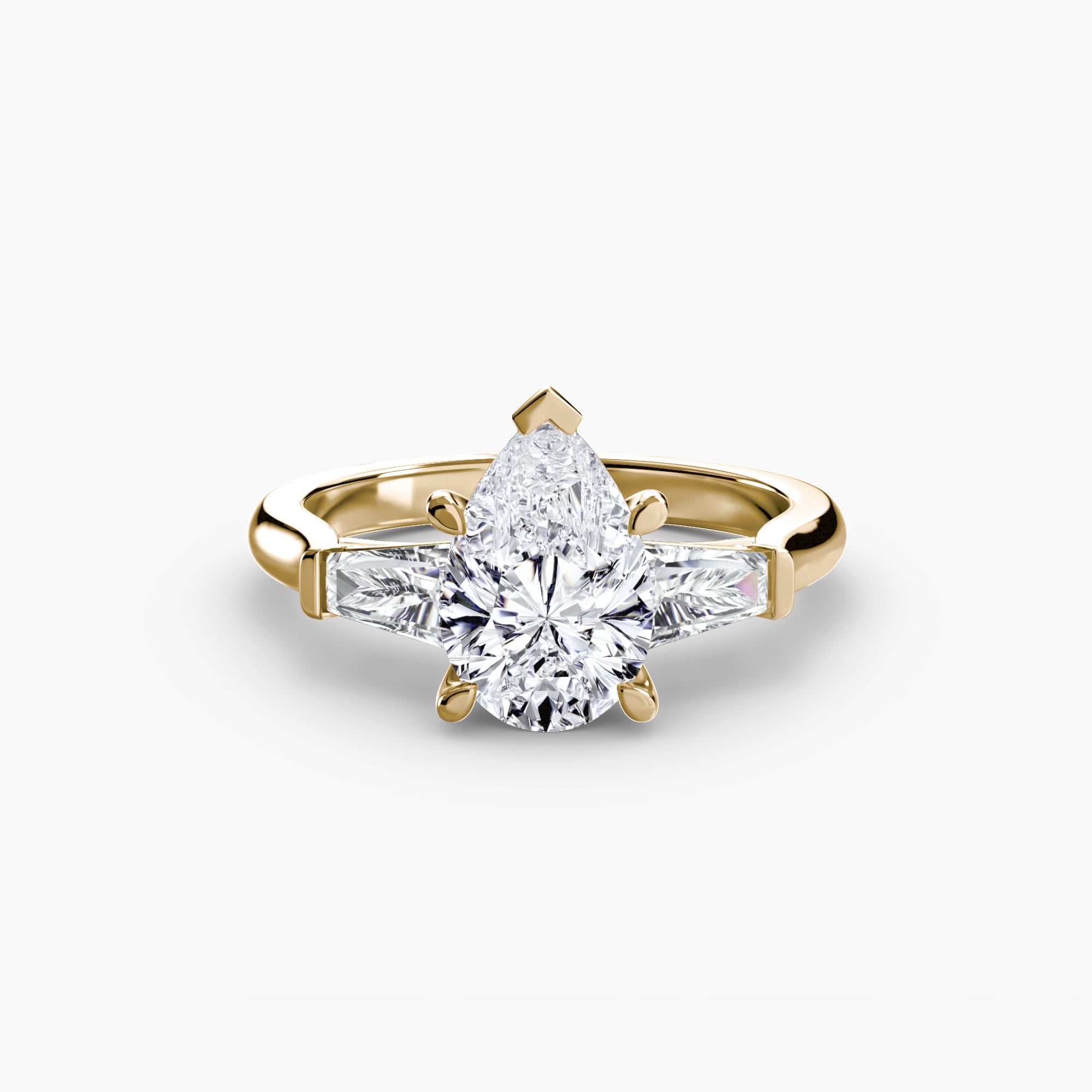 The MICHAEL ISAAC Three-Stone Ring features a gold band with a large pear-shaped center diamond and two baguette side stones, showcased on a plain white background.