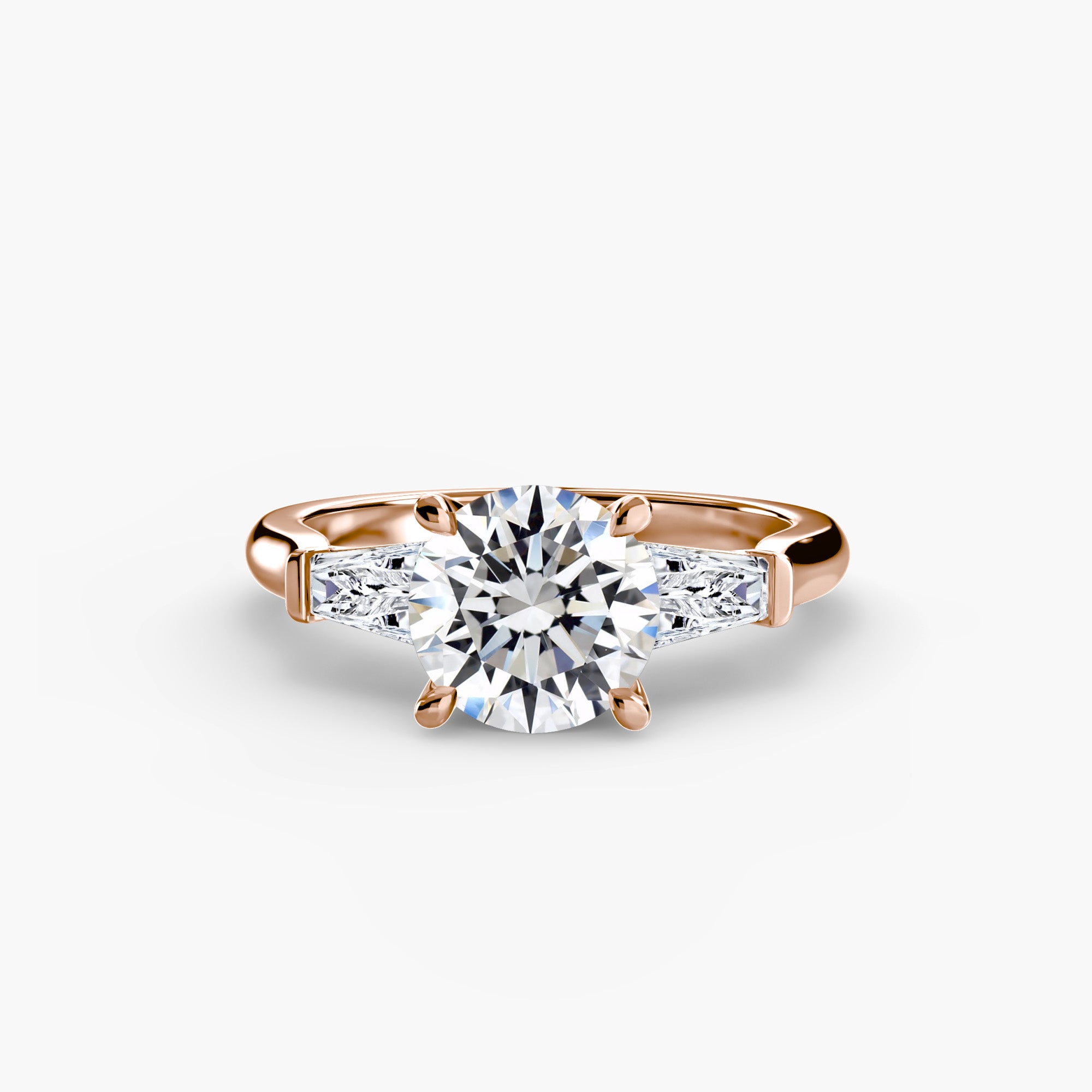 The MICHAEL ISAAC Three-Stone Ring features a rose gold band with a round center diamond and two baguette side diamonds, shown on a plain white background.