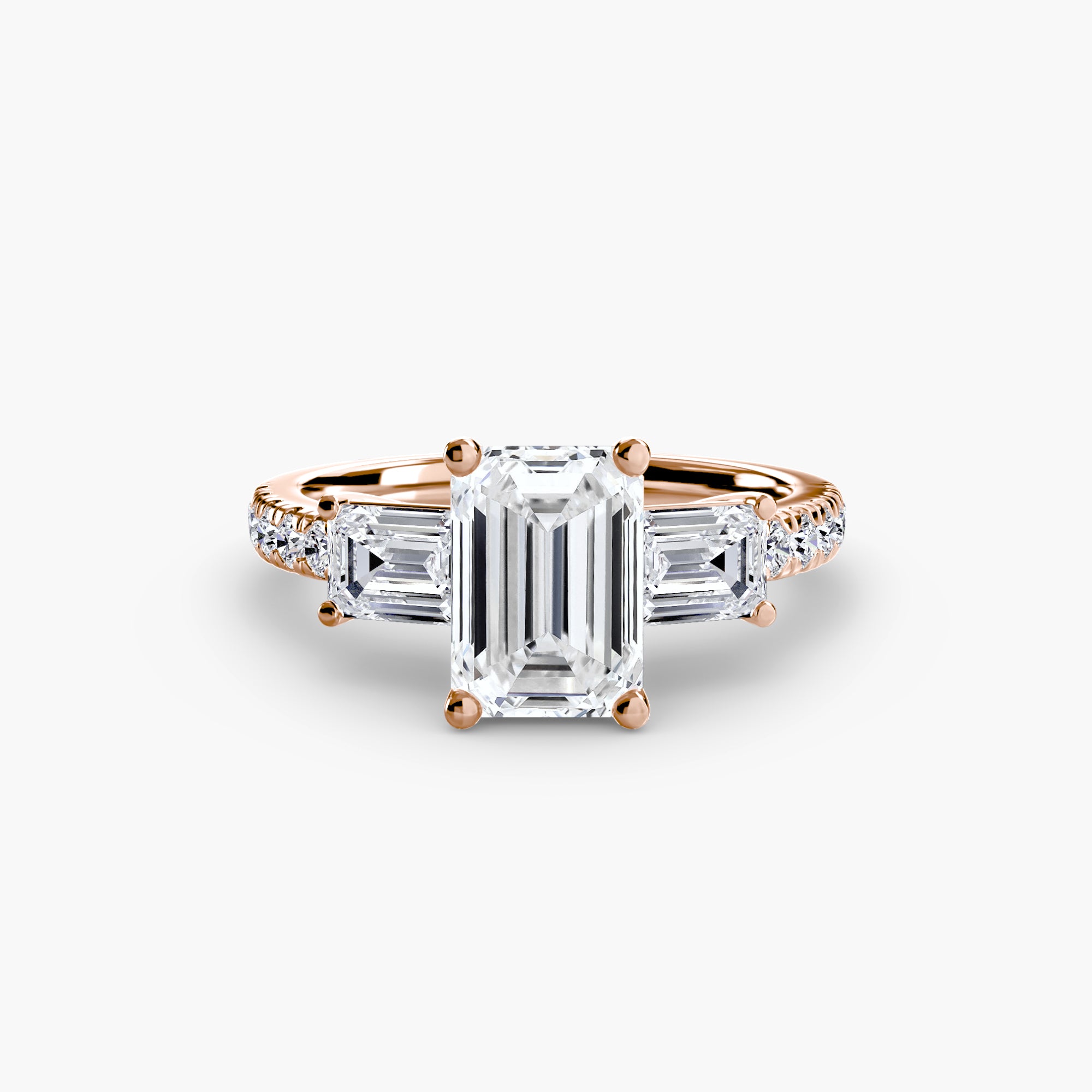 The MICHAEL ISAAC Three-Stone Ring with Pavé Band 4 features a large emerald-cut diamond between two trapezoid diamonds, set in rose gold with a pavé band, shown on a plain light background.