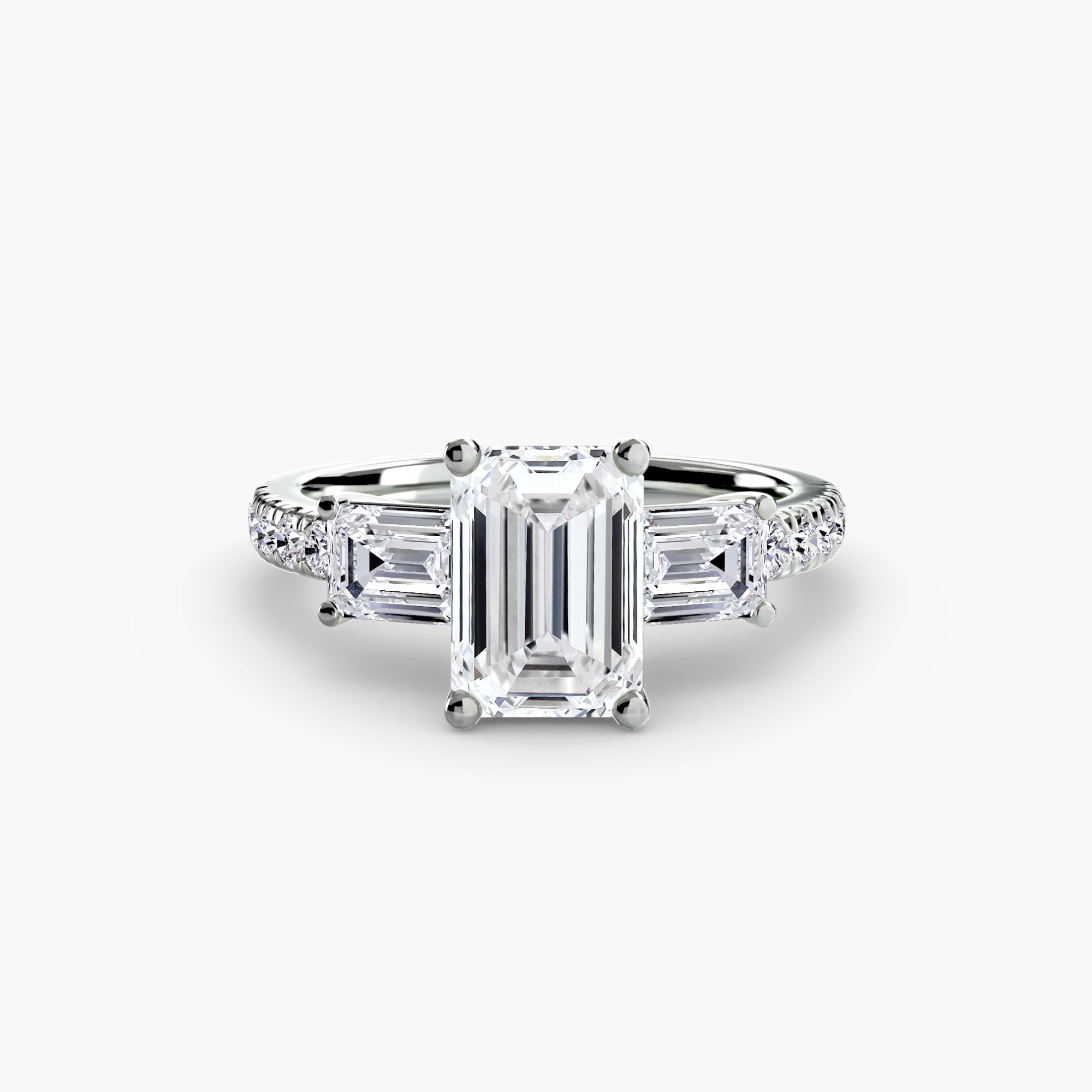 The MICHAEL ISAAC Three-Stone Ring with Pavé Band 4 features a striking emerald-cut diamond center, two trapezoid side diamonds, and a pavé white gold band adorned with sparkling round accents.
