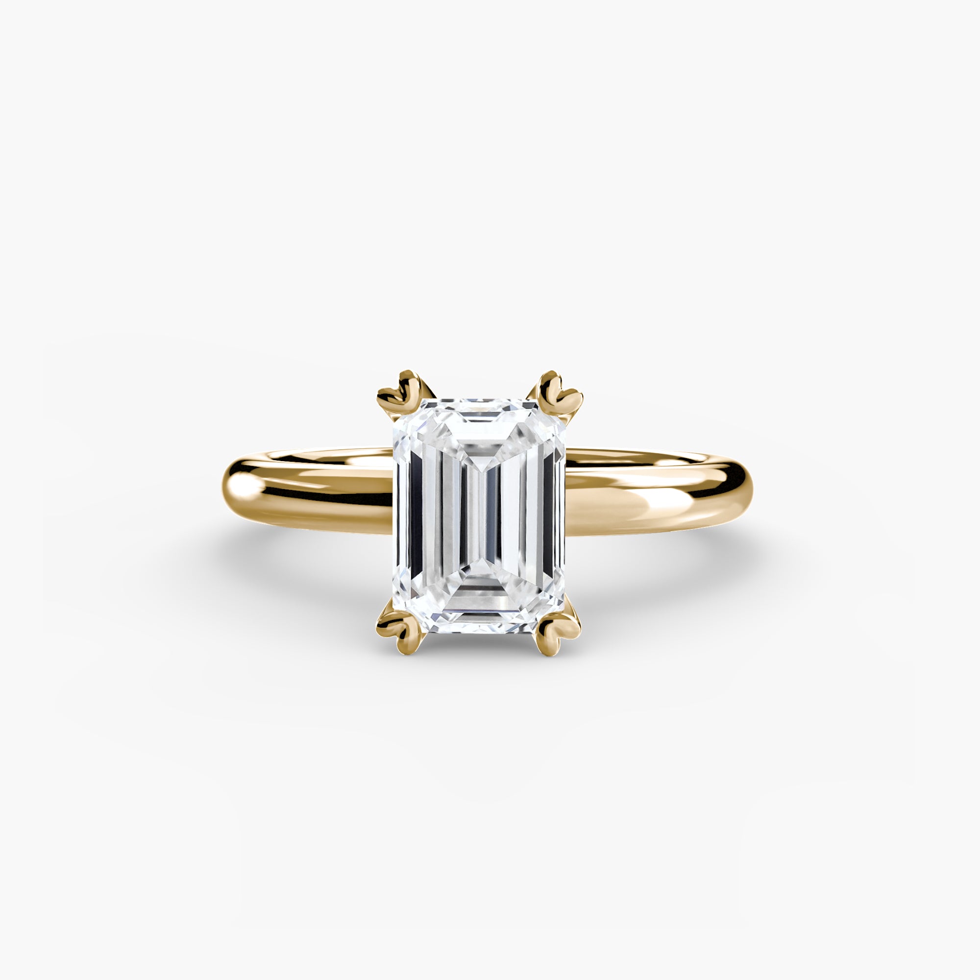 The MICHAEL ISAAC Solitaire ring 2 is a minimalist gold band with an emerald-cut diamond solitaire in a classic four-prong setting, shown on a plain white background.