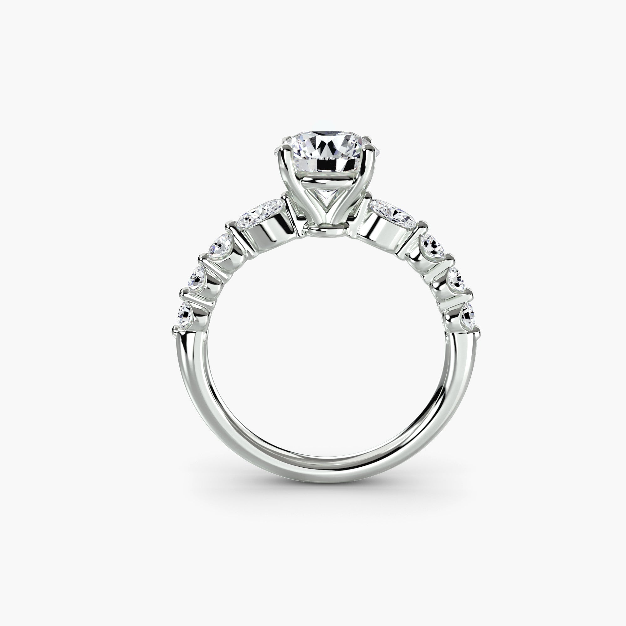 The Tiered Accent Ring by MICHAEL ISAAC features a striking round center diamond with smaller side stones on a white gold or platinum band, displayed upright on a plain white background—an ideal piece for everyday elegance.
